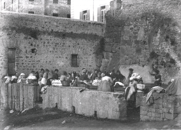 [Ariccia (Italy), women washing clothes beneath a medieval wall]